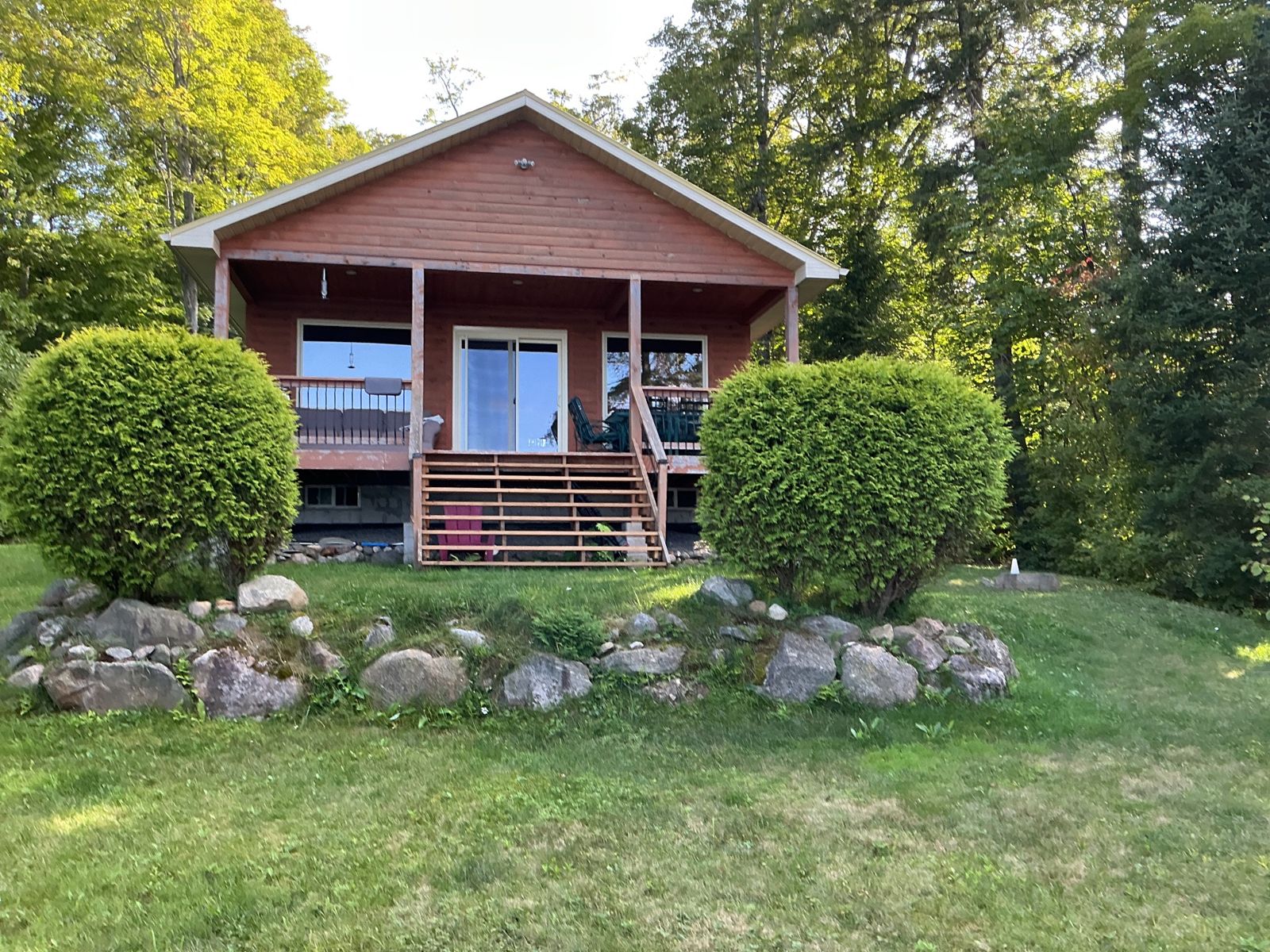 The cottage in August before work began, with clipped cedars either side of the steps and mown lawn in front